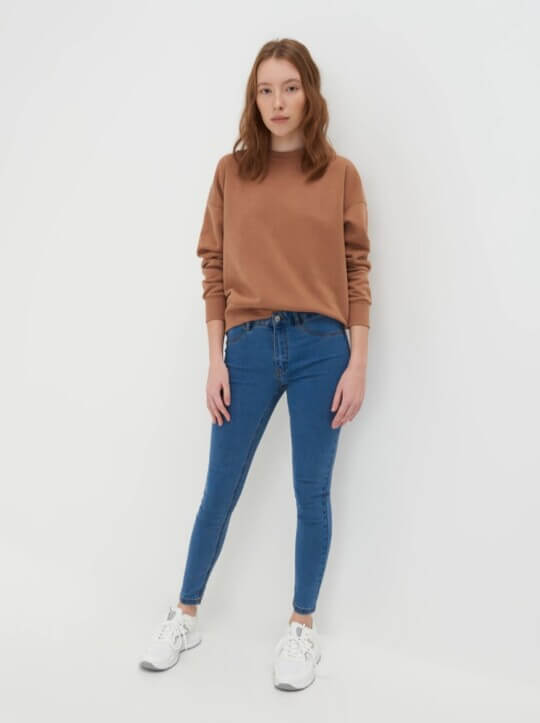 With sneakers and sweatshirt