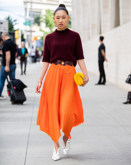 Bright orange skirt adds volume to the hips