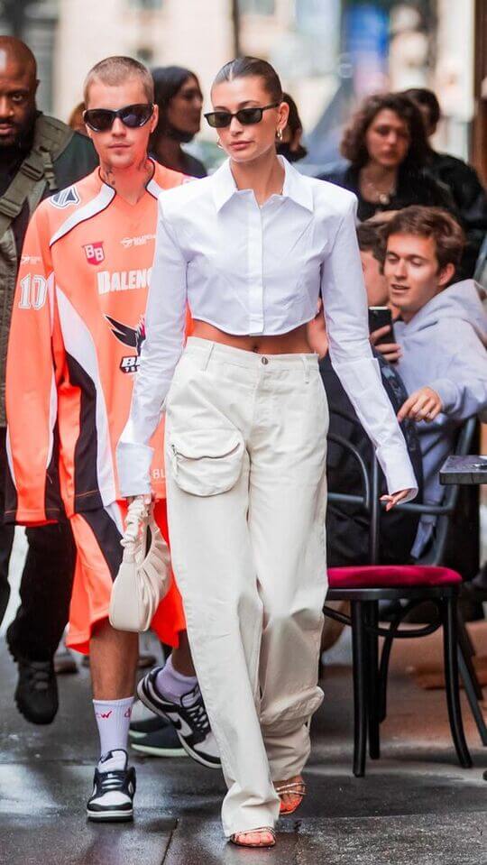 Hailey Bieber in a classic white shirt and light-colored kargo pants